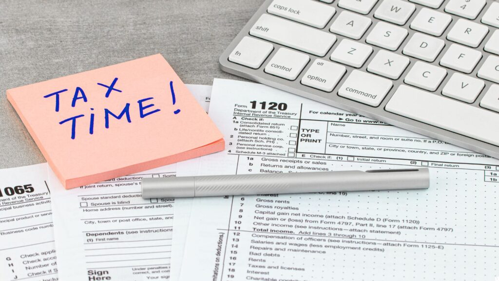 Tax time sticky note reminder placed above tax forms