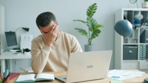 Small business owner reviewing financial paperwork and calculating expenses
